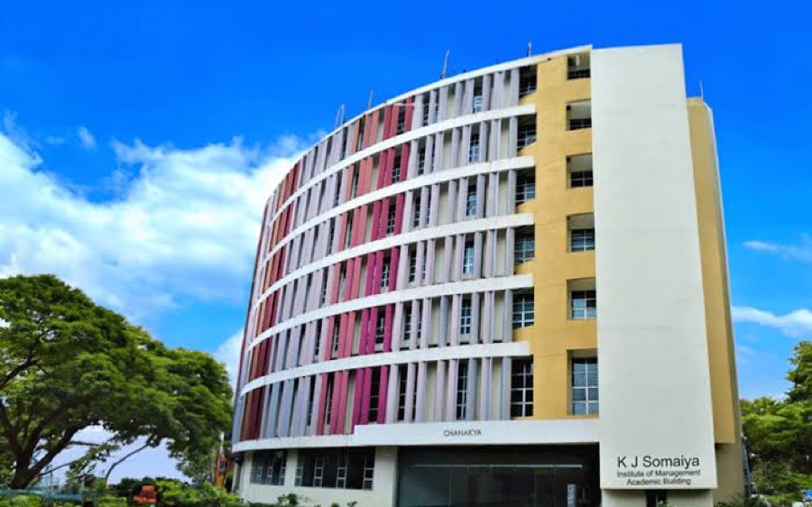 The K J Somaiya Institute of Management academic building at Vidyavihar, Mumbai — a curved facade with pink and white vertical fins